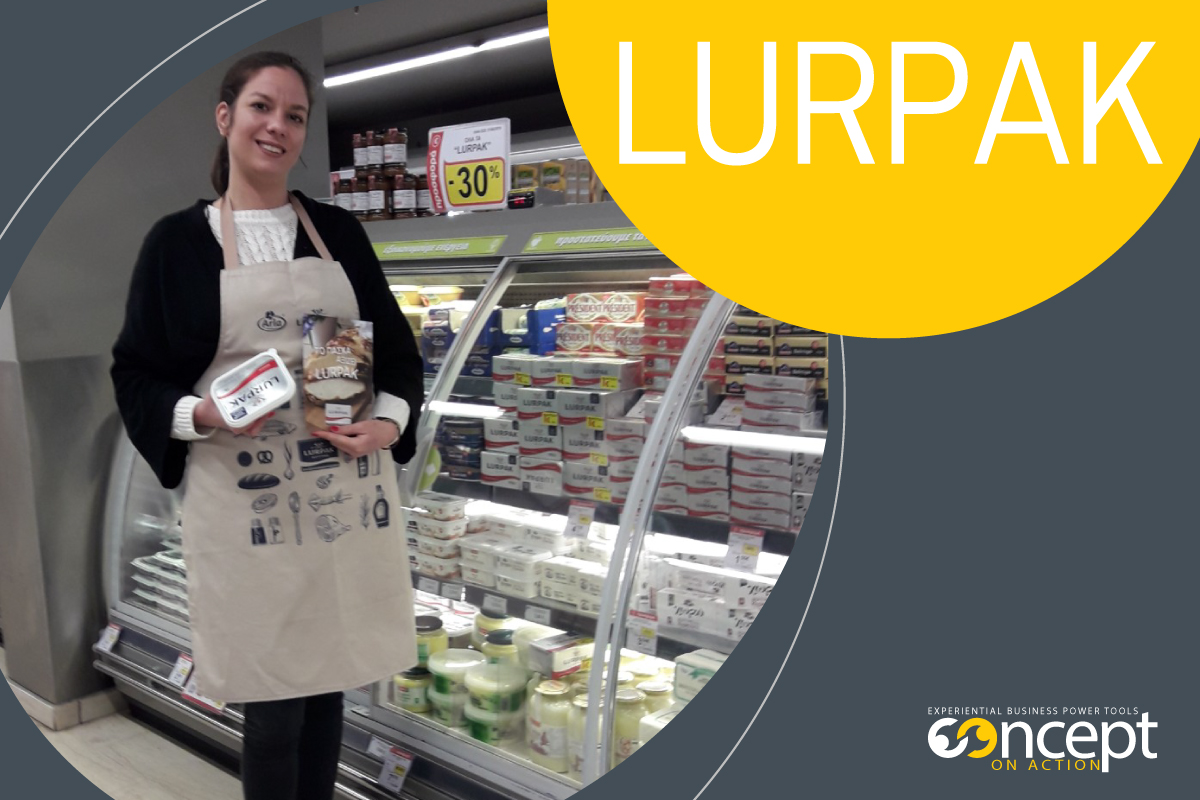 promoter της Concept on Action προωθεί προϊόντα Lurpak μπροστά από ψυγείο Super market